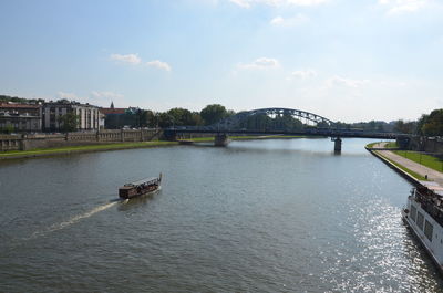 Bridge over river in city against sky