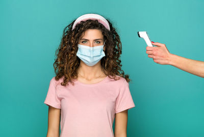 Portrait of a teenage girl against blue background