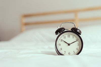 Close-up of clock on bed