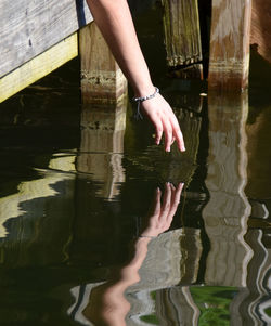 Midsection of woman with reflection in lake