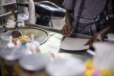 Midsection of man preparing food in kitchen