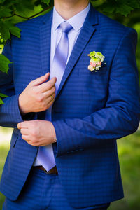 Midsection of groom standing on field