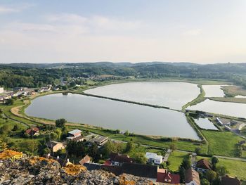 High angle view of city by lake against sky