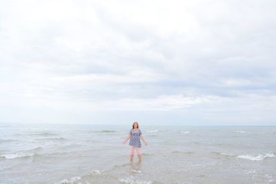 Woman standing on beach against sky