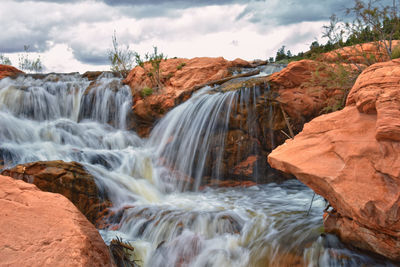 Scenic view of waterfall against sky