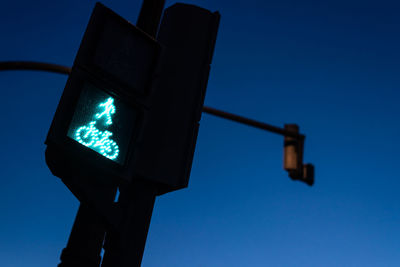 Low angle view of road signal against clear blue sky