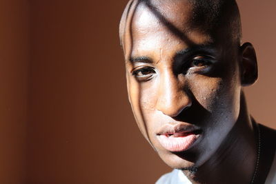 Portrait of young man against brown wall