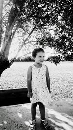 Girl standing on tree trunk