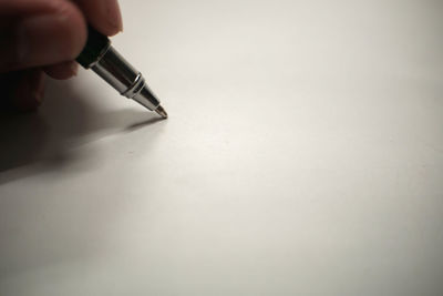 Close-up of hand holding pen on table