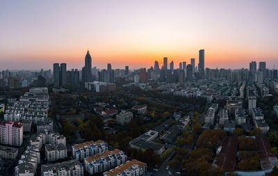 Aerial view of buildings in city during sunset