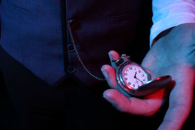 Close-up of hand holding pocket watch