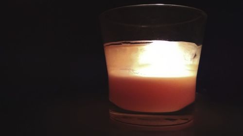Close-up of illuminated candle against black background