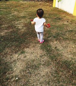 Rear view of baby girl standing on grass