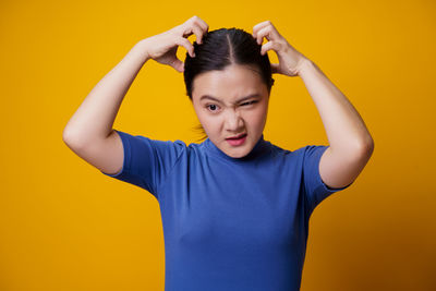 Portrait of man standing against yellow background