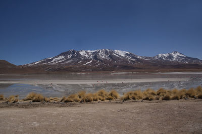 Scenic view of lake and snowcapped mountains against sky during winter