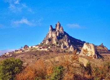 Rock formations on landscape against blue sky