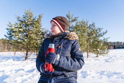 Young woman standing on snow covered field