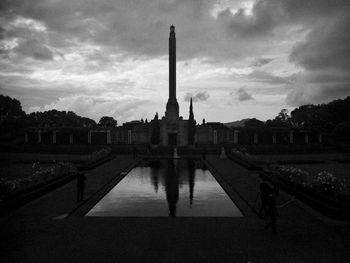 View of monument in city against cloudy sky