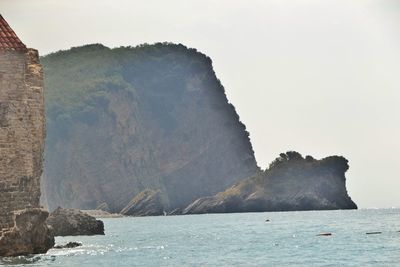 Rock formations by sea against sky