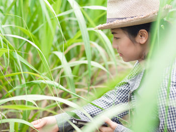 Girl looking away while holding plants