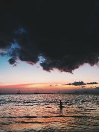 Silhouette sailboats in sea against sky during sunset