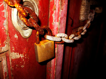 Close-up of rusty chain on wooden wall