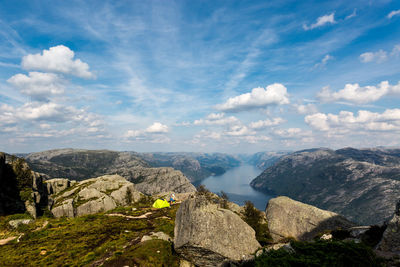 Scenic view of mountains against cloudy sky during sunny day