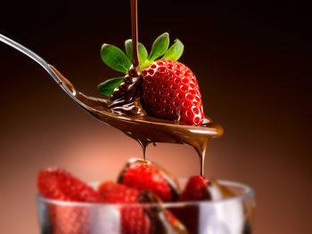 Close-up of raspberries in bowl against black background