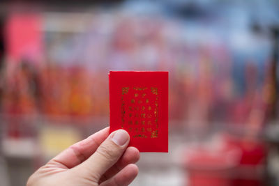 Close-up of hand holding red camera