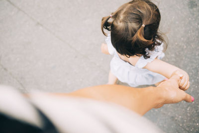 Toddler girl walking holding mother's hand