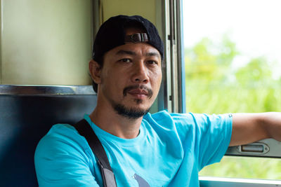 Portrait of man looking away while sitting in train