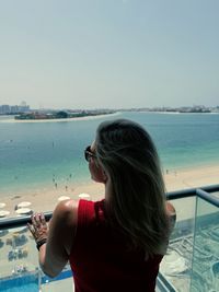 Rear view of woman looking at sea against sky