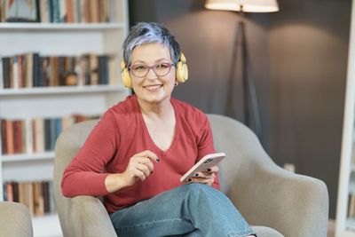 Young woman sitting on sofa at home