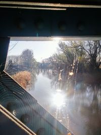 Close-up of wet car by trees against sky