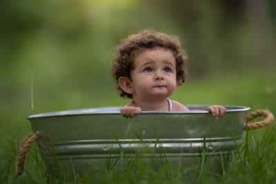 Cute girl sitting in container outdoors