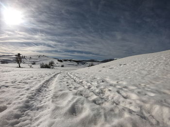 Scenic view of snow covered land against sky