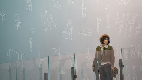 Portrait of woman standing against wall