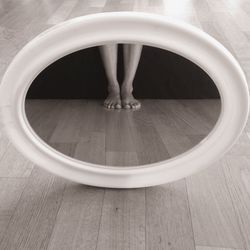 Low section of woman standing on hardwood floor