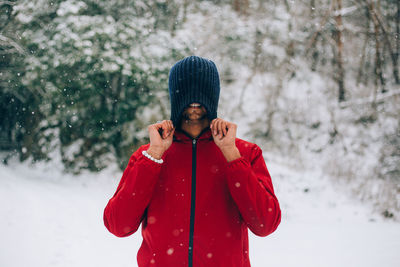 Portrait of young man standing in snow