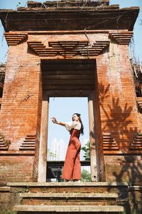 Side view of woman standing at entrance