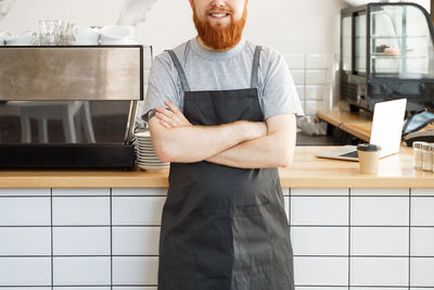 Portrait of young man standing in kitchen