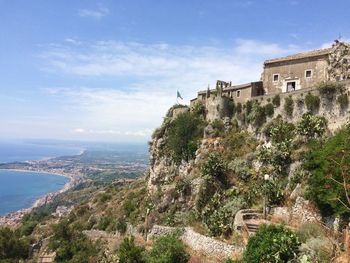 Fort on mountain by sea against sky