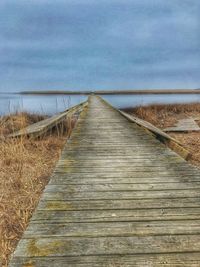 Boardwalk on beach against sky