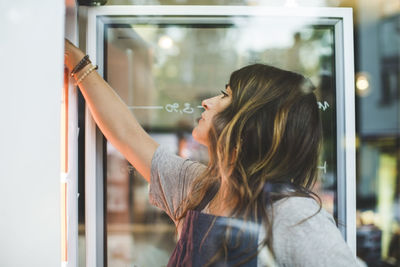 Female employee searching in refrigerator at deli