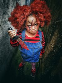 Portrait of girl with face paint and knife during halloween