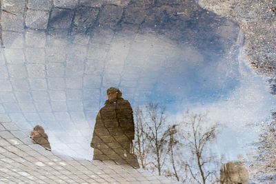 Reflection of woman on puddle