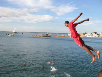 Man diving in sea against sky