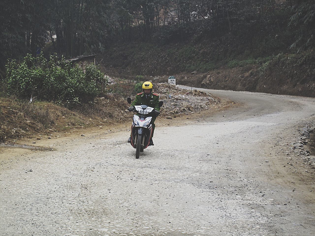 REAR VIEW OF PEOPLE RIDING MOTORCYCLE ON ROAD