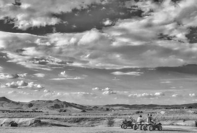 Scenic view of field against cloudy sky