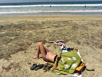 Woman lying down on sand at beach